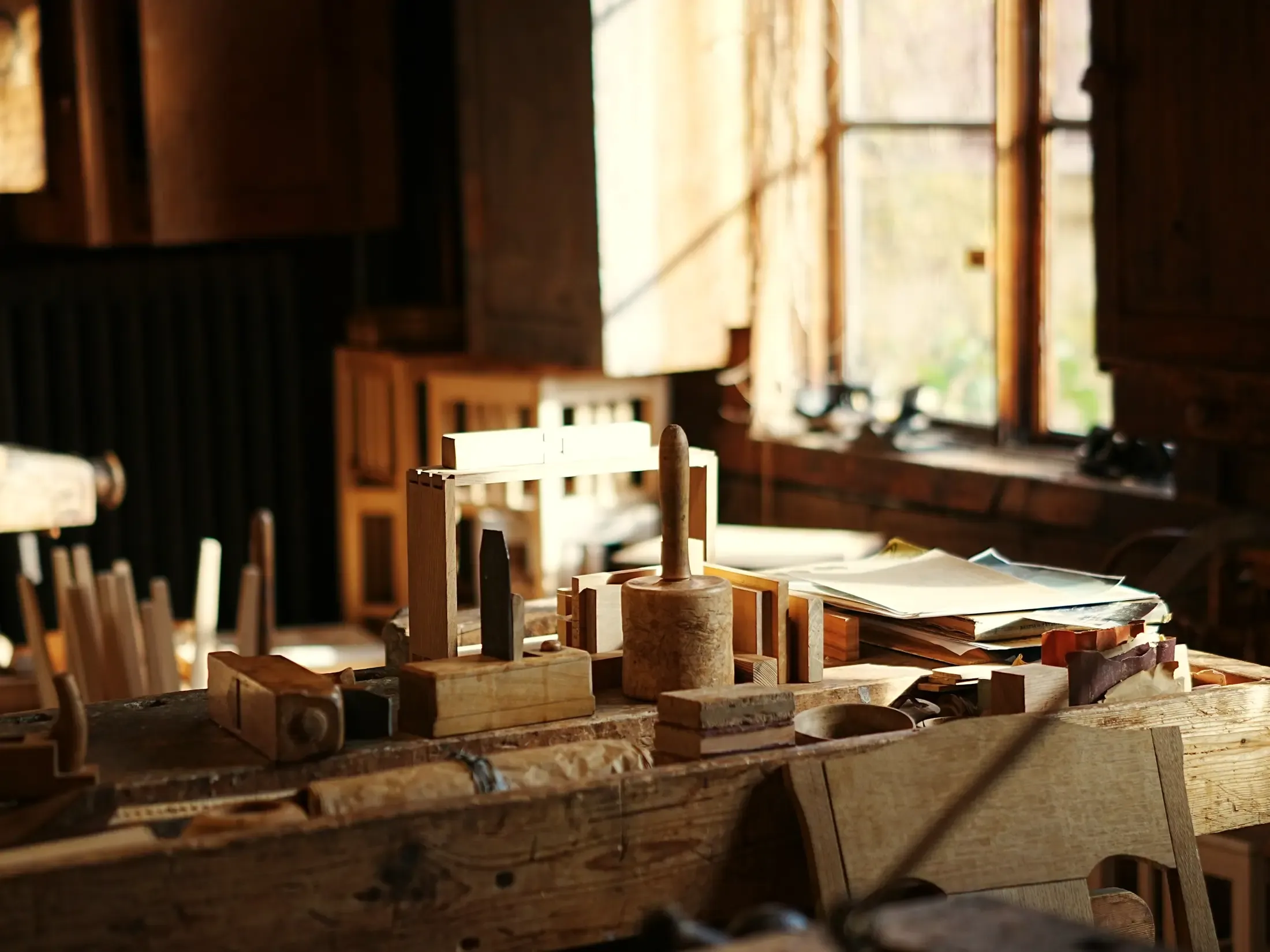 Wooden hand tools laid out on a workbench in a sunlit workshop