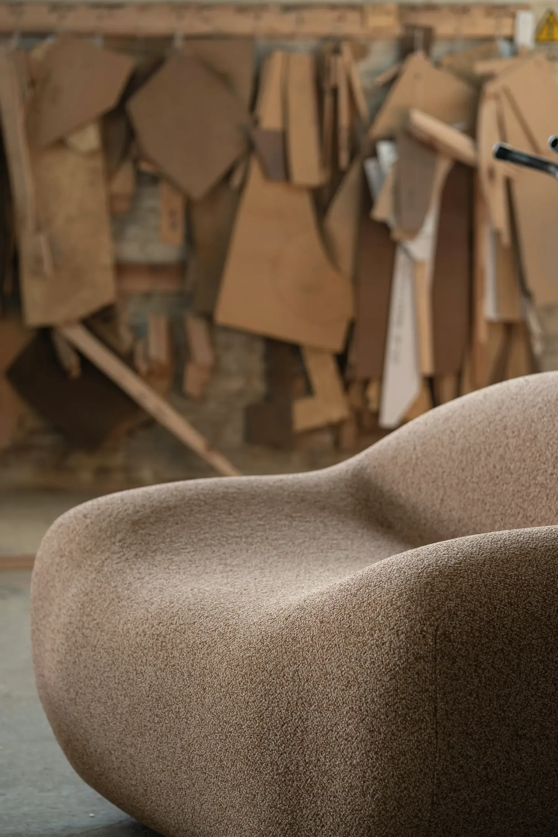 An upholstered shape on a stand in a workshop, softly lit